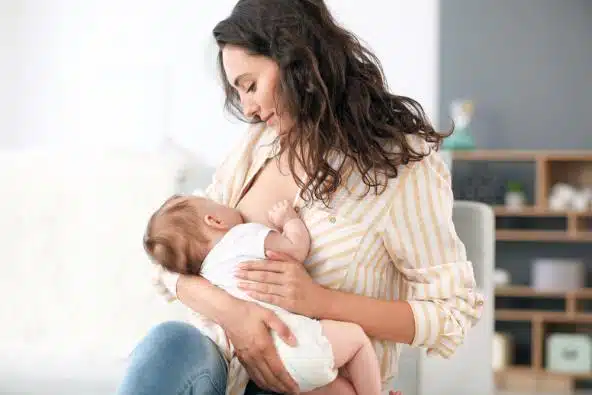 Mulher amamentando bebê, mostrando a importância do leite materno para o desenvolvimento de uma criança.